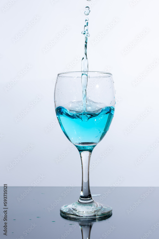 Liquid of beautiful blue color is poured into a glass Liquid of beautiful blue color is poured into a glass