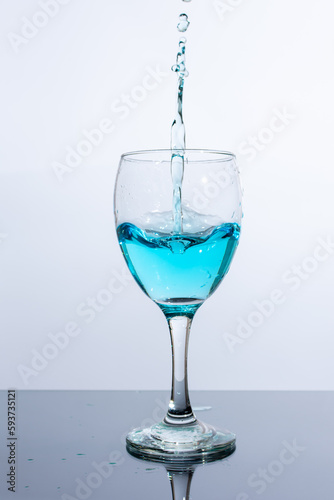 Liquid of beautiful blue color is poured into a glass