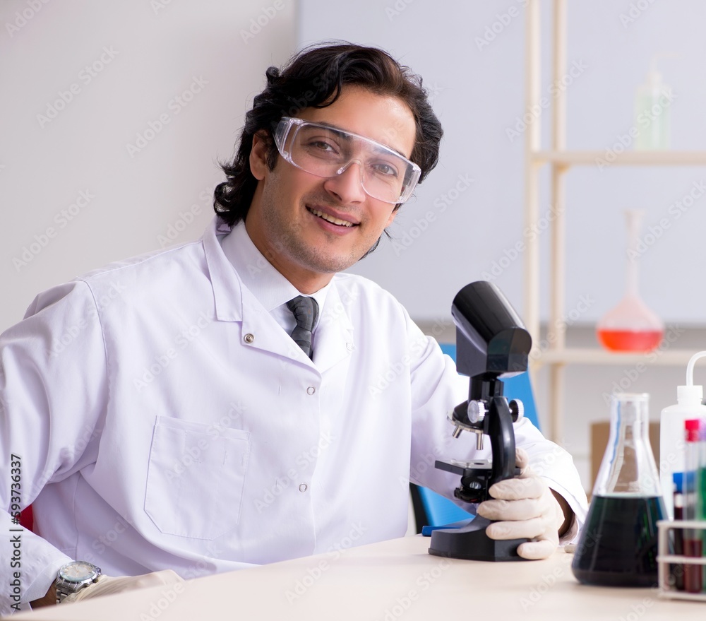 Young handsome chemist working in the lab Young handsome chemist working in the lab