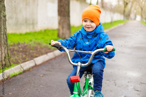 Cute little preschool kid boy riding on bicycle in park