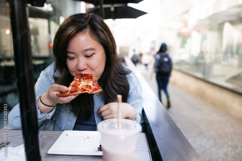 Girl eating pizza on patio downtown. Girl eating pizza on patio downtown.