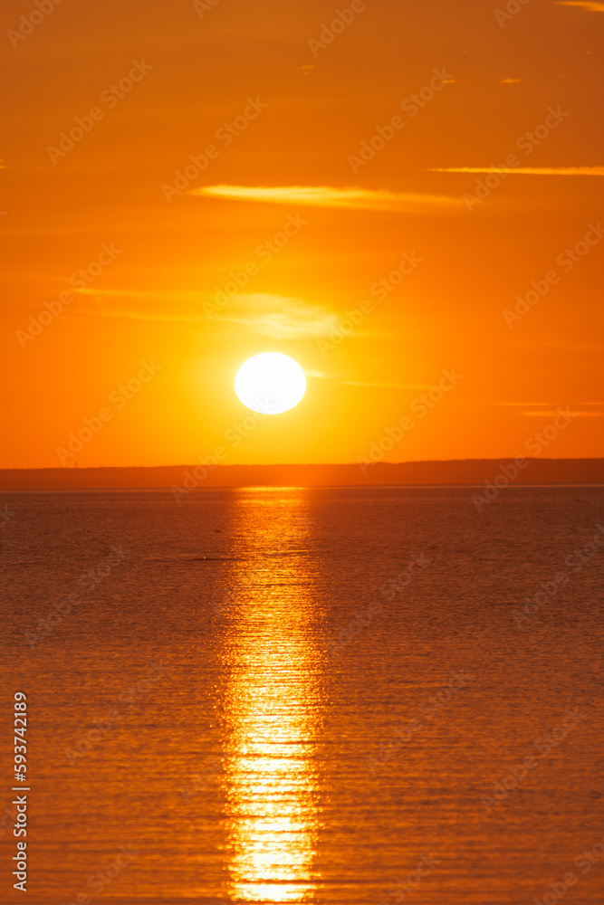 sunset on background of ocean or sea, beautiful orange color in nature. freedom and rest, observation and contemplation of view of the sun and sky. reflections of light play of waves