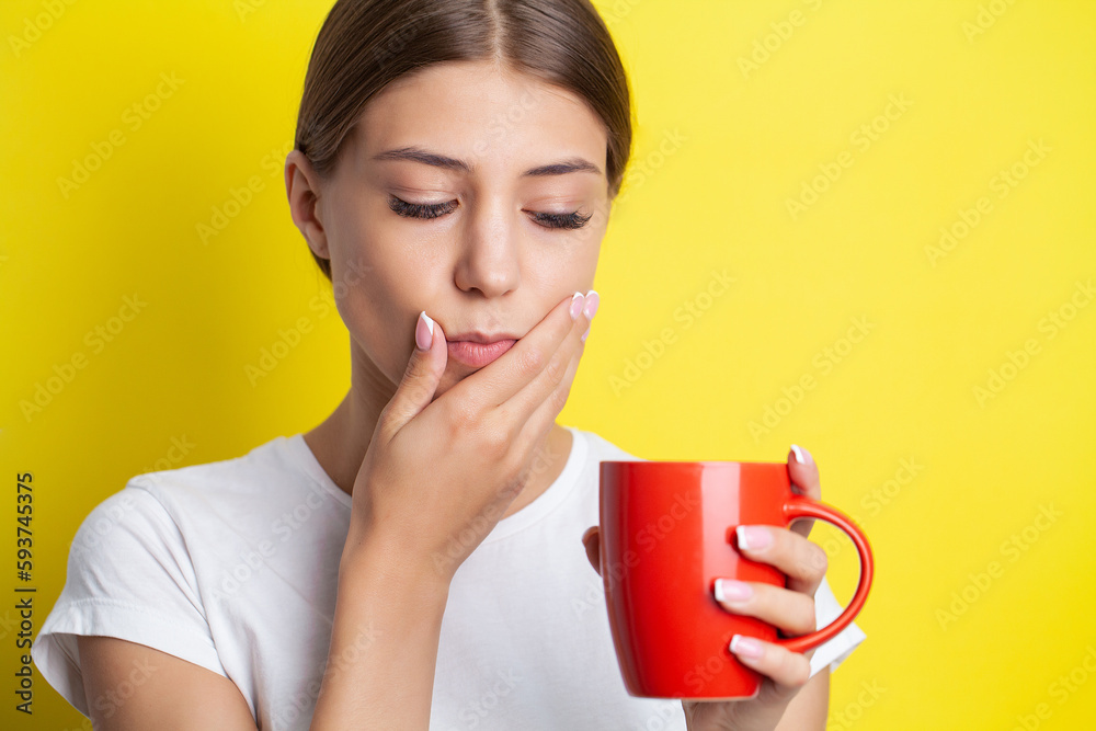 A young woman feels a toothache and holds the place of pain with her hands A young woman feels a toothache and holds the place of pain with her hands