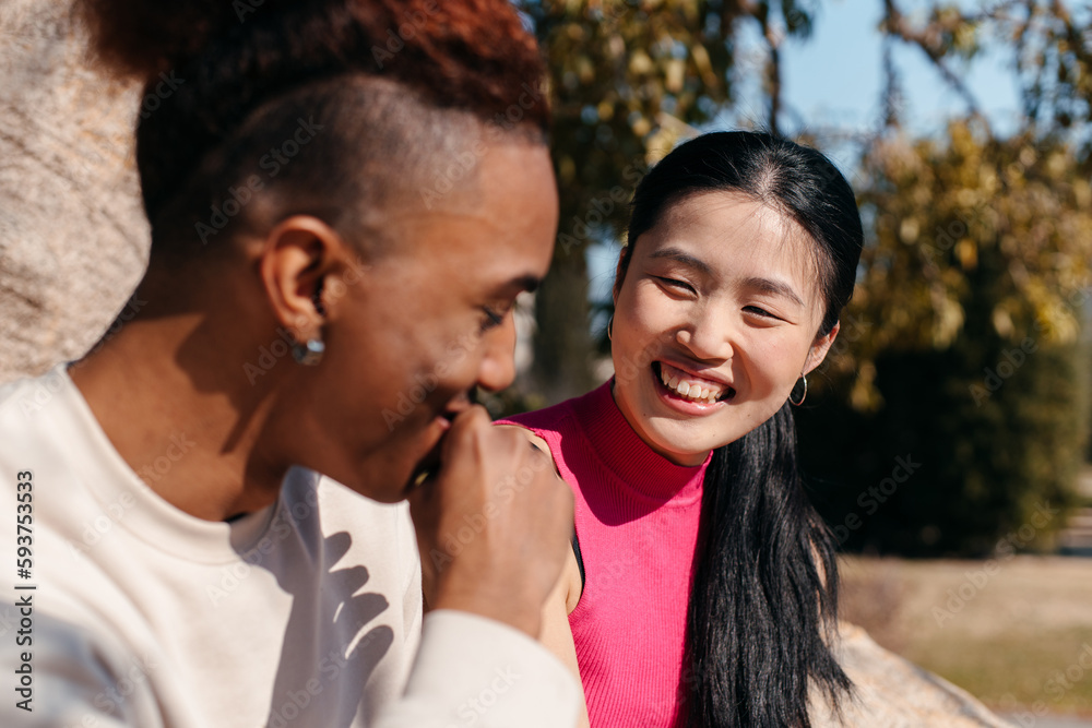 Multiracial couple laughing on a date outdoors Multiracial couple laughing on a date outdoors