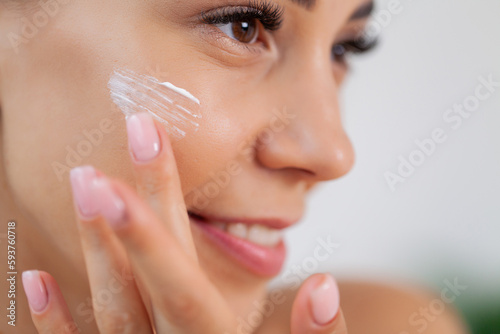 Skin care, woman use skin care products at home in light bathroom