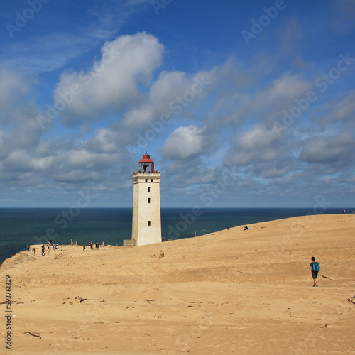 Old lighthouse partly covered by a high sand dune. Rubjerg Knude,