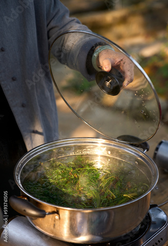 Closeup paint water being boiled with fresh wormwood photo