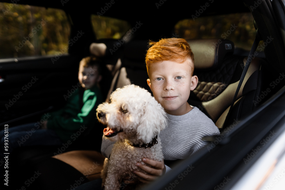 Two children and a dog in the passenger seat of a car Two children and a dog in the passenger seat of a car