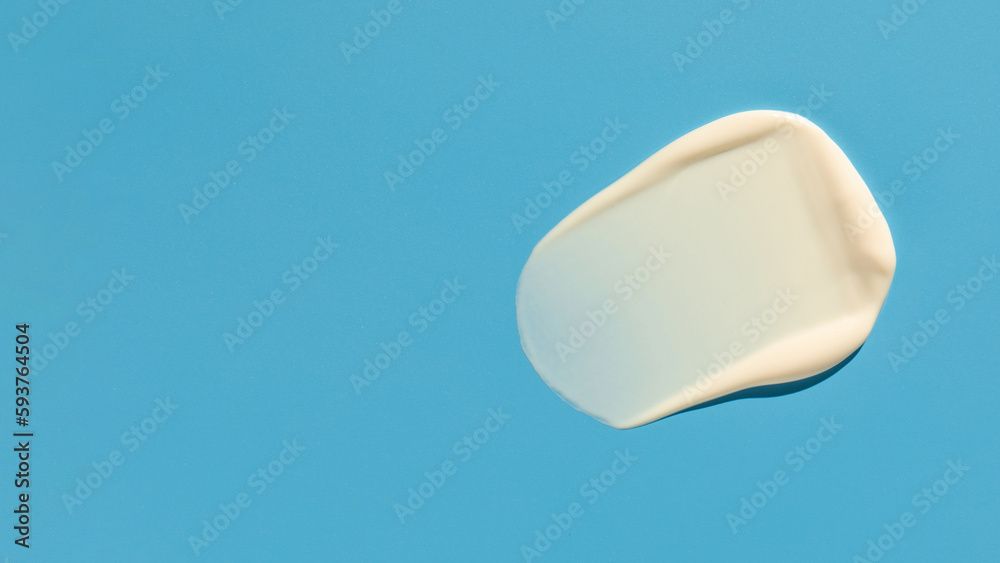 Swatch. The texture of a white cosmetic product, cream on a blue background. Sample of skin care cosmetics. Copy space Swatch. The texture of a white cosmetic product, cream on a blue background. Sample of skin care cosmetics. Copy space