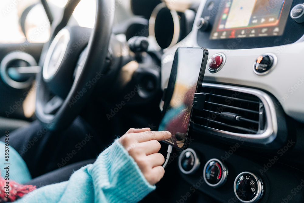 Crop woman using smartphone while driving car Crop woman using smartphone while driving car