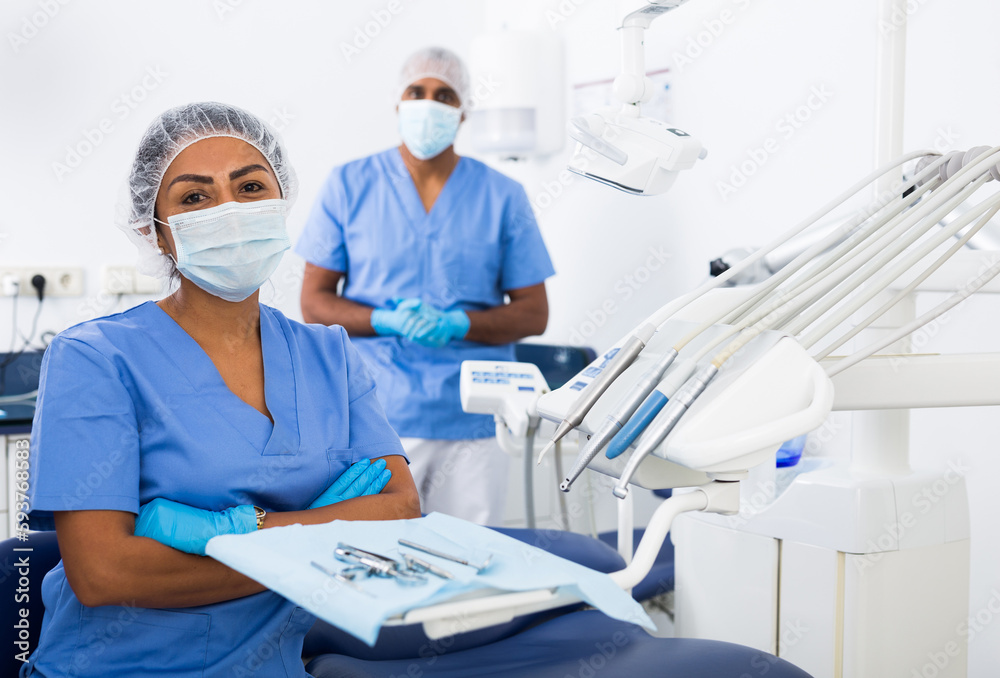 Naklejka premium Portrait of professional qualified woman dentist posing with arms crossed at modern dental clinic..