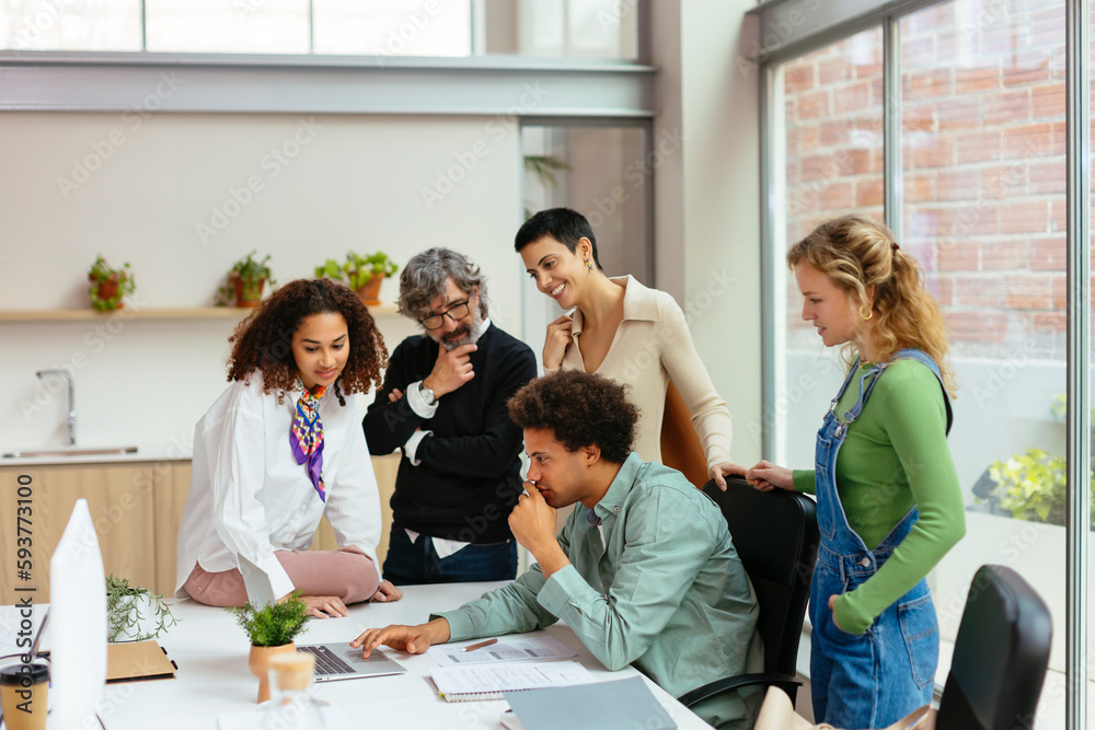 Group of diverse colleagues discussing project in office Group of diverse colleagues discussing project in office