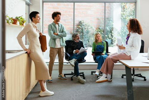 Group of diverse coworkers talking in workspace