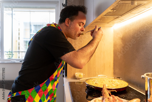 Man Tasting Food While Cooking At Home