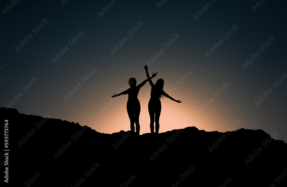Happy female friends silhouettes having fun at sunset Happy female friends silhouettes having fun at sunset