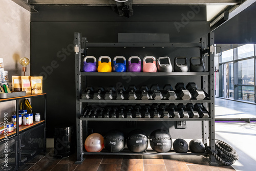 Gym rack with a set of dumbbells, kettlebells and exercise balls photo
