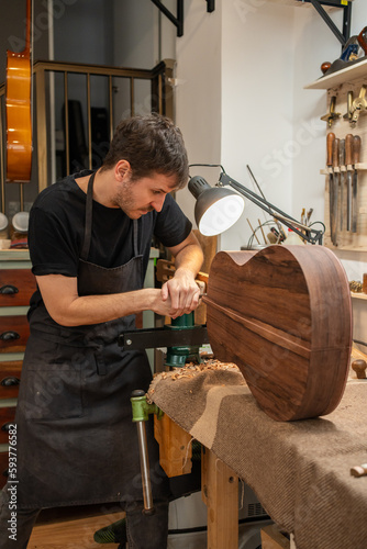 Luthier, Guitar Maker, Working In The Workshop.  photo