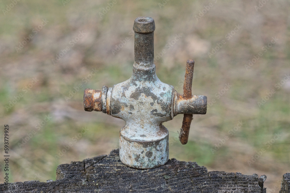 part one metal copper valve from an old faucet pipe on a gray table in the street