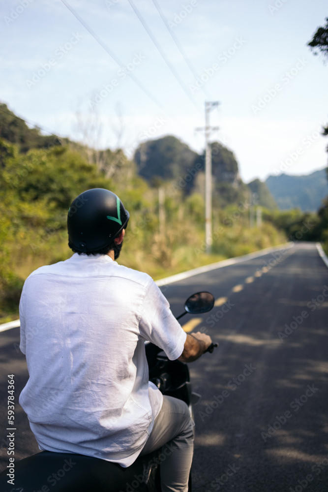Tourist touring the roads of Southeast Asia on a scooter Tourist touring the roads of Southeast Asia on a scooter