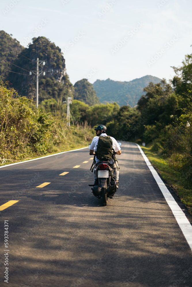 Traveler driving a scooter in the nature of islands of Vietnam Traveler driving a scooter in the nature of islands of Vietnam
