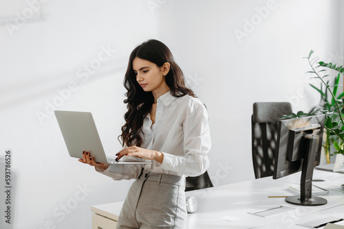 Young woman working in a bright office with houseplants photo