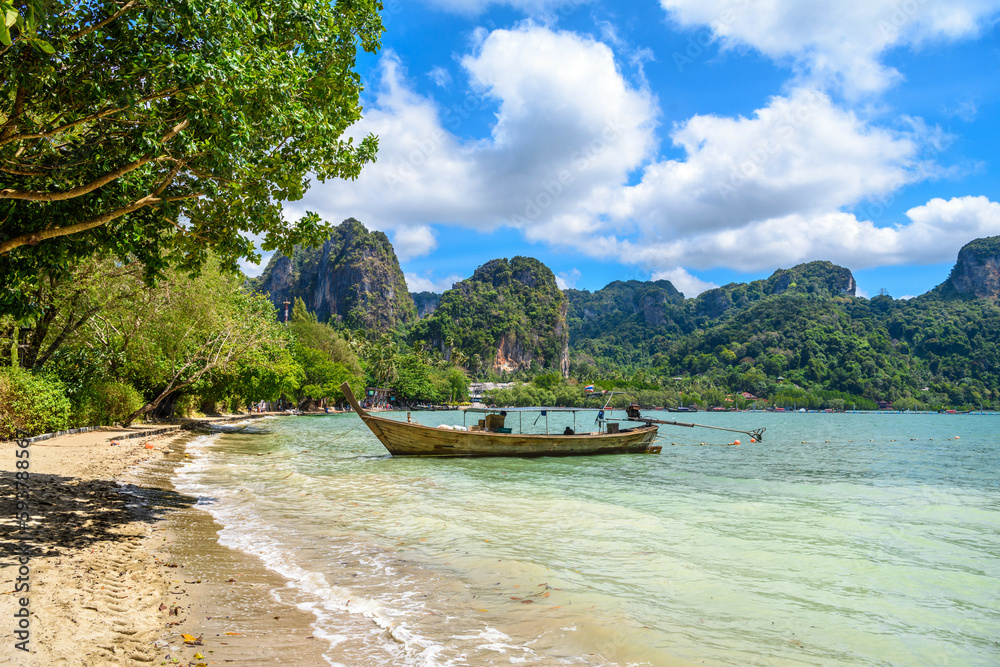 Obraz premium Long boats, rocks and cliffs covered with tropical trees, azure water on Ao Phra Nang Beach, Railay east Ao Nang, Krabi, Thailand