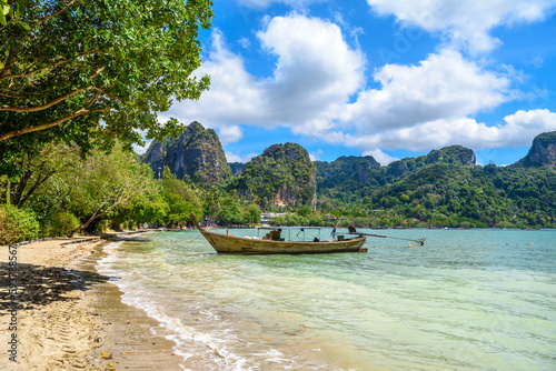 Long boats, rocks and cliffs covered with tropical trees, azure water on Ao Phra Nang Beach, Railay east Ao Nang, Krabi, Thailand