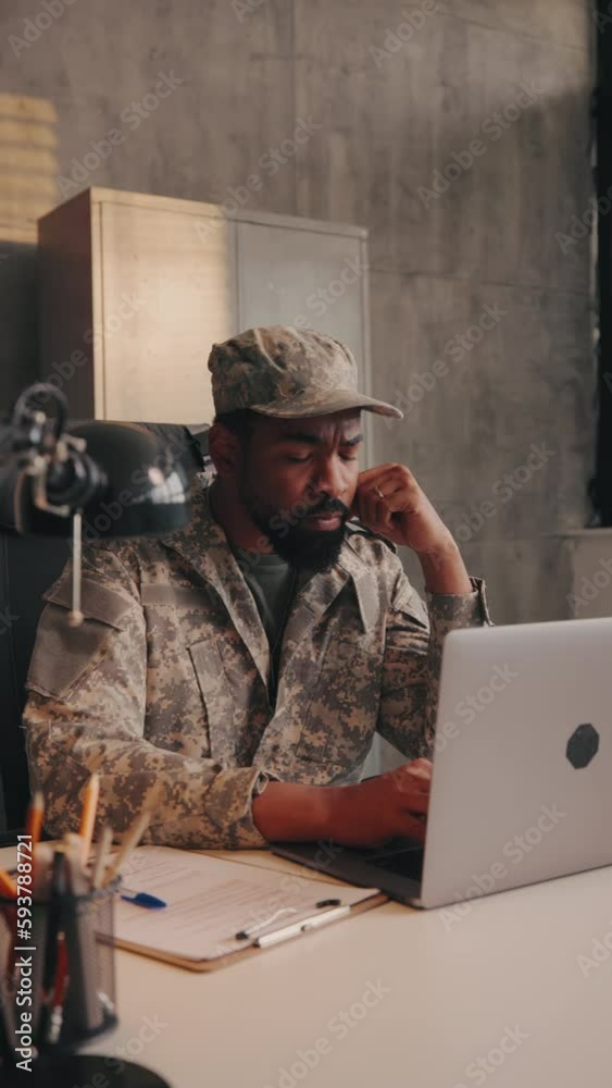 Army officer typing on laptop in office. Army officer typing on laptop in office.