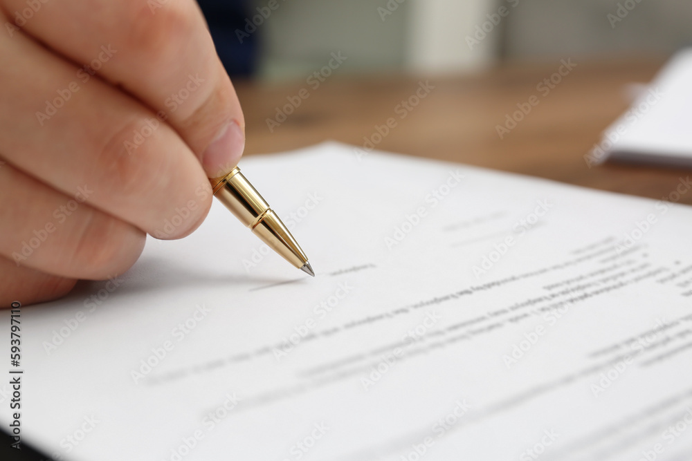 Man signing document at table, closeup view Man signing document at table, closeup view