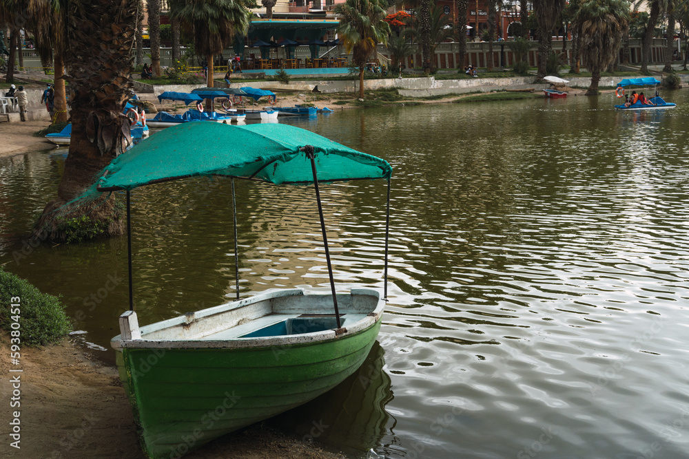 Obraz premium colored boat in the Huacahina lagoon, ica peru