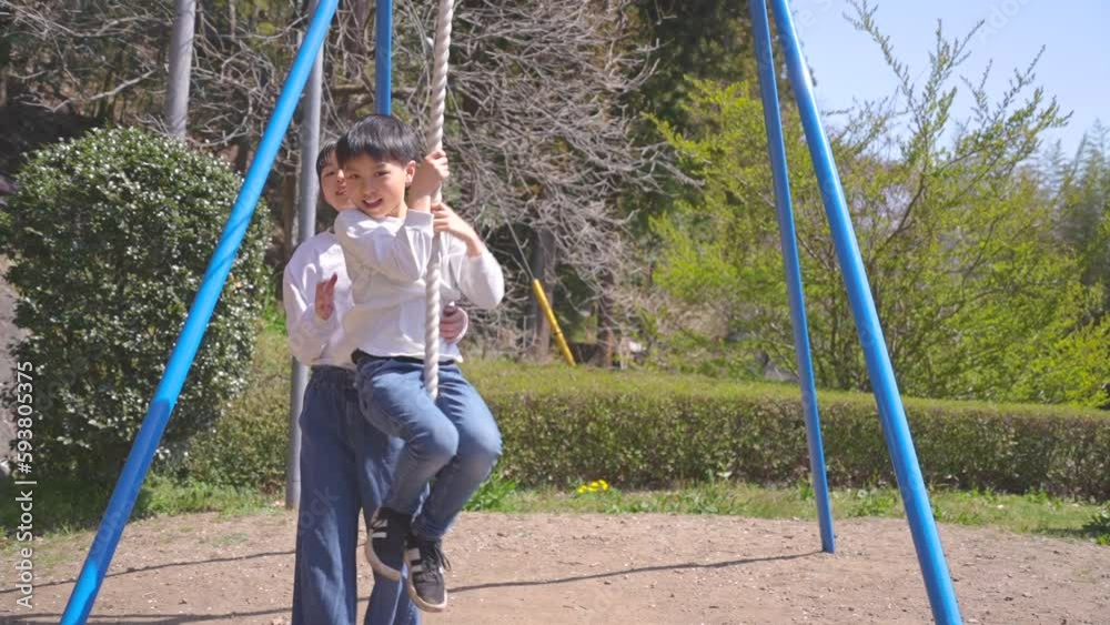 桜が咲く公園で遊ぶ日本人の男の子と女の子 桜が咲く公園で遊ぶ日本人の男の子と女の子