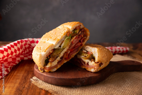 Mexican Torta. Sandwich made with common bread in Mexico, it can be telera, bolillo or bagette, split in half and filled with various ingredients, in this case spicy pork leg with Oaxaca cheese. photo