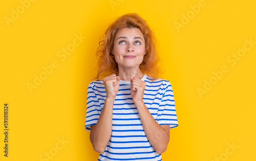 dreaming redhead woman portrait isolated on yellow background. portrait of young redhead woman