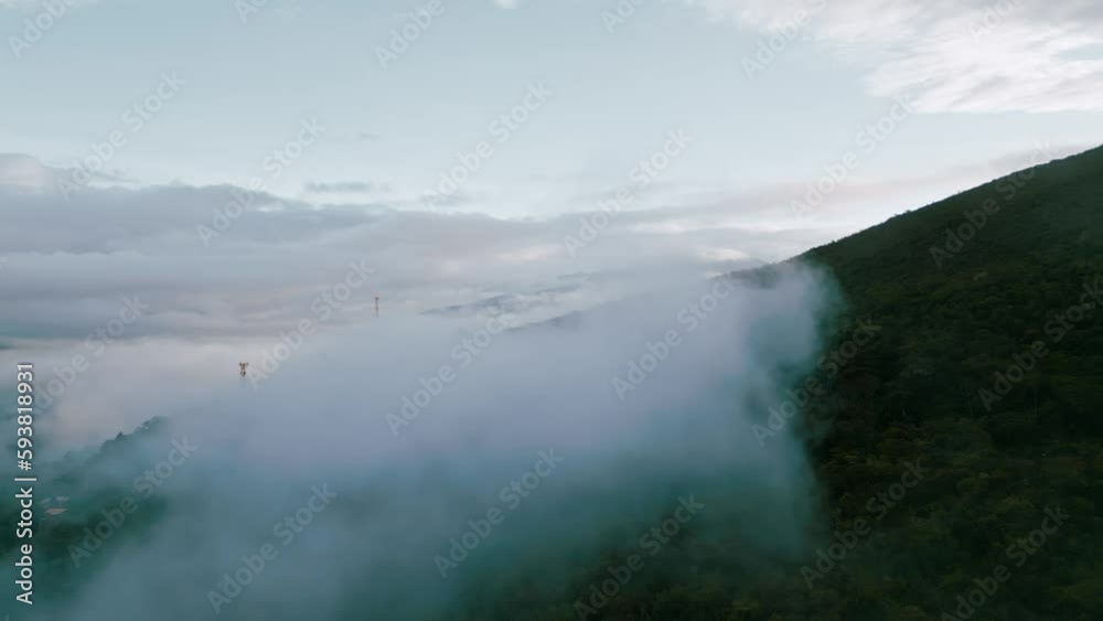 Glide above the clouds, as majestic mountain peaks emerge in the background, adorned with radio towers and providing a breathtaking backdrop to the verdant Yungas cloud forest below. Glide above the clouds, as majestic mountain peaks emerge in the background, adorned with radio towers and providing a breathtaking backdrop to the verdant Yungas cloud forest below.