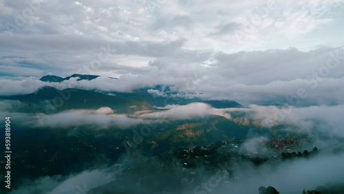 Marvel at the magnificent Yungas cloud forest with majestic mountain peaks in the backdrop and the charming town of Coroico visible beneath the lush forest canopy. photo
