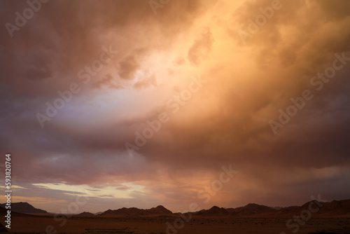 Dramatic storm clouds at sunset in the desert mountain landscape