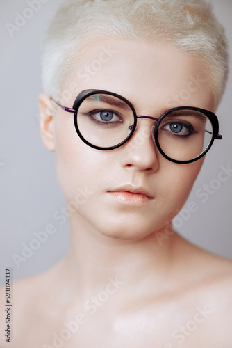 Portrait of beautiful blonde woman with short haircut in black glasses isolated on white background.