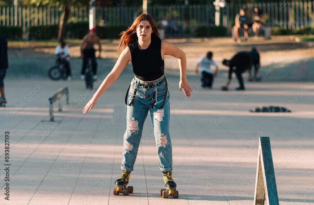 bella mujer joven andando en patines de 4 ruedas en la ciudad al atardecer en un día de verano bella mujer joven andando en patines de 4 ruedas en la ciudad al atardecer en un día de verano