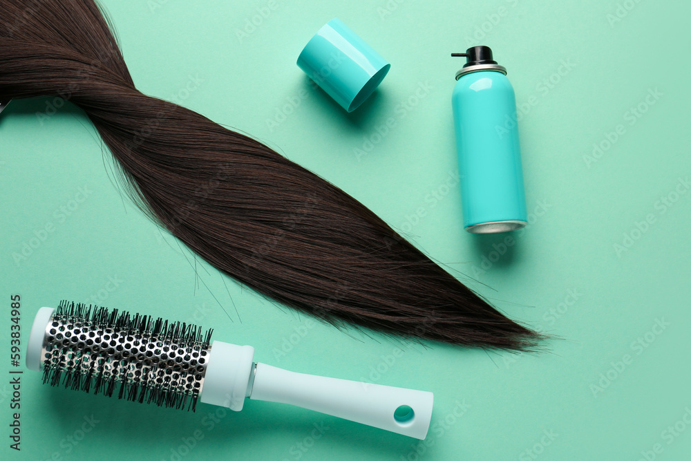 Naklejka premium Bottle of hair spray, brush and strand on color background