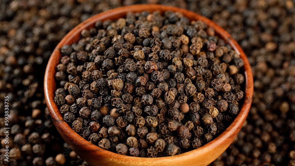 Dried black peppercorns in wooden bowl. Dry seasoning in wooden bowl Dried black peppercorns in wooden bowl. Dry seasoning in wooden bowl