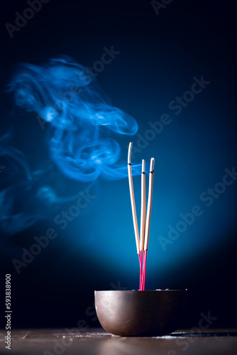 Incense sticks and incense stick smoke on black backgrond with white backlit