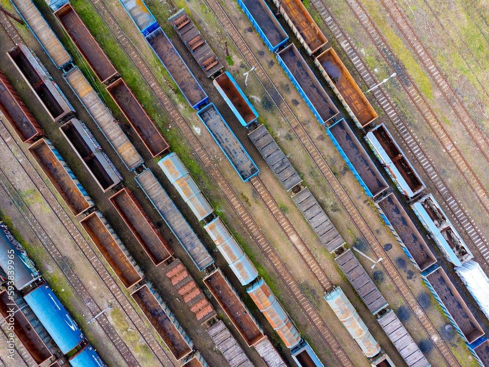 Aerial view of freight trains. Aerial view from flying drone of colorful freight trains at railroad station. Carriages of goods on a railroad. Heavy industry. Industrial conceptual scene with trains.