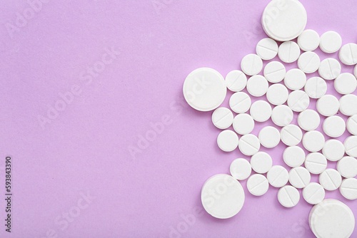 White pills on lilac background