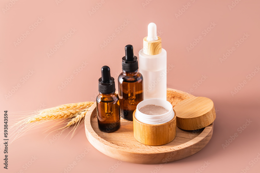 Fototapeta premium Multifunctional moisturizing serum and cream for face and body skin care in a cosmetic set of natural self-care products. Brown background.