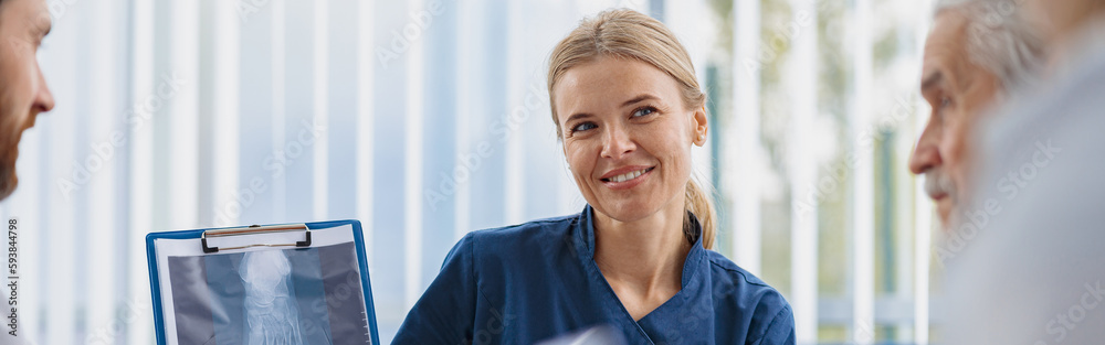 Group of doctors sitting at meeting table in conference room during medical seminar Group of doctors sitting at meeting table in conference room during medical seminar