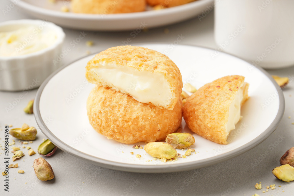 Plate with tasty choux dessert on light background Plate with tasty choux dessert on light background