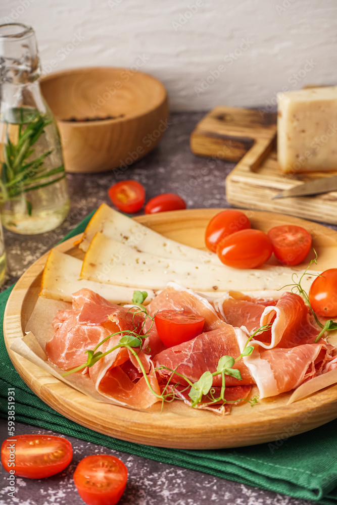 Plate with slices of tasty jamon and cheese on table Plate with slices of tasty jamon and cheese on table