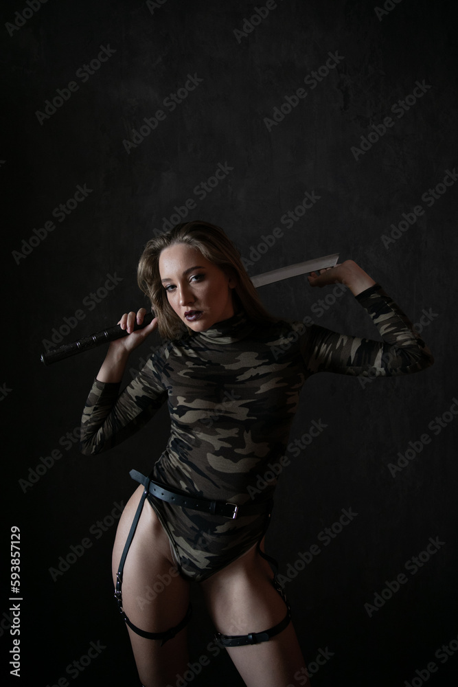 military woman in camouflage in a black room military woman in camouflage in a black room
