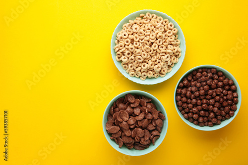 Set of various breakfast cereals on yellow background. Space for text