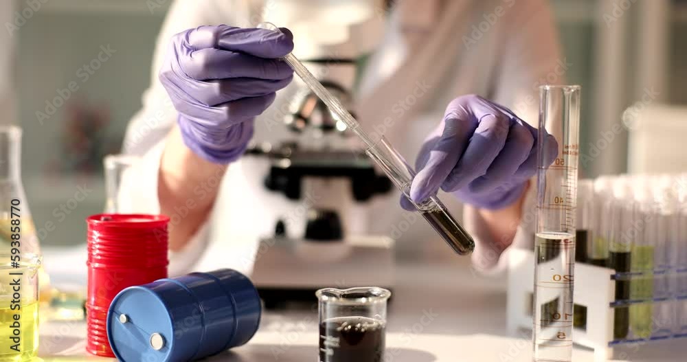 Scientist drips yellow liquid of petroleum products from pipette into